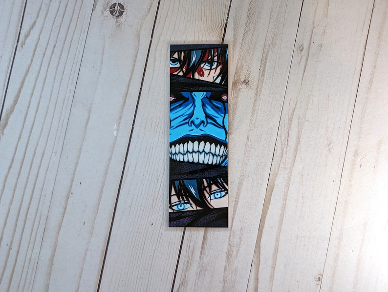 Pode incluir: Marcador de livros retangular com arte em estilo anime. O design apresenta um rosto azul com um sorriso largo e dentes, e olhos espreitando de ataduras pretas. As se&ccedil;&otilde;es superior e inferior mostram olhos com &iacute;ris azuis.