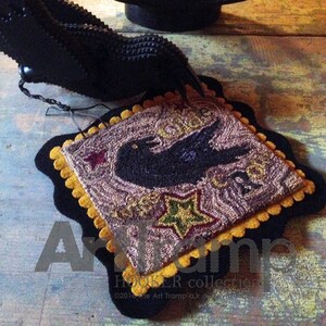 May include: A black and gold needlepoint rug featuring a black bird and stars. The rug has a scalloped edge and is framed with a black border. The text "Once Upon a Time" is stitched into the rug.