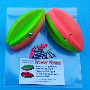 May include: Two green and pink fishing planers in a clear plastic bag with screws and small pink and white floats. The bag also includes a card that reads "Prowler Planers 3 ways to rig them! Plane to the left Plane to the right Or flip direction when given a POP! www.SteerltFishing.com Made in the US under Patent # 6,874,271 by Bullet Bobber Enterprises"