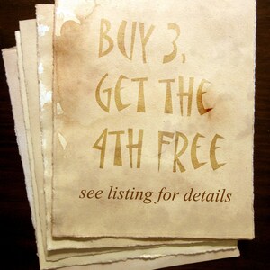 May include: A stack of aged, cream-colored paper with brown edges. The top sheet has the text "BUY 3, GET THE 4TH FREE" printed in a gold-colored font. The text "see listing for details" is printed below in a smaller font.