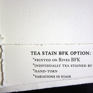 May include: Off-white paper sheets with hand-torn deckled edges and a subtle embossed BFK Rives France watermark. The text reads: TEA STAIN BFK OPTION: *PRINTED ON RIVES BFK *INDIVIDUALLY TEA STAINED BY HAND *HAND-TORN *VARIATIONS IN STAIN.