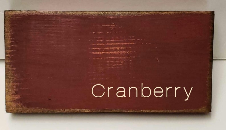 A wooden sign with a red background and the word 'Cranberry' written in white text.