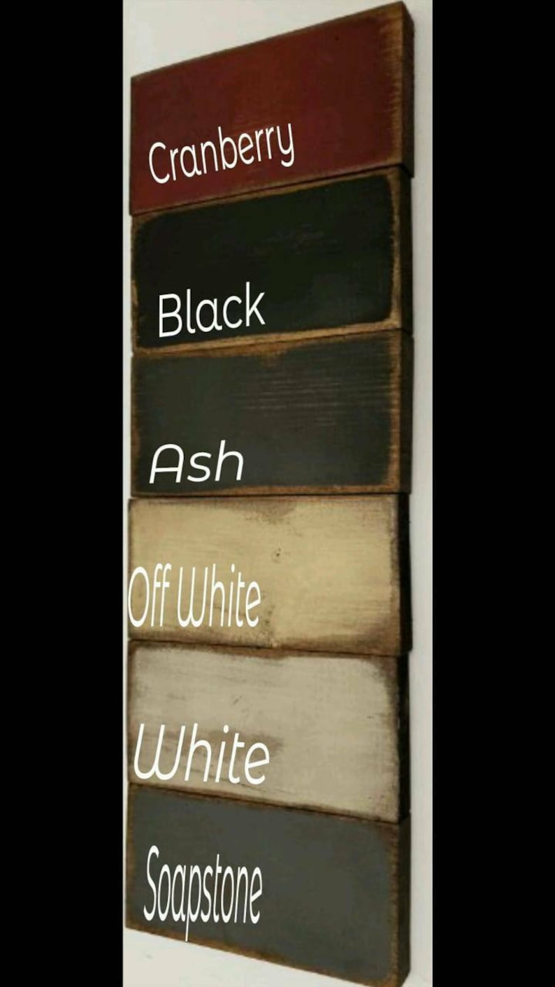 Six wooden planks painted in different colors: cranberry, black, ash, off white, white, and soapstone. The colors are labeled on each plank.