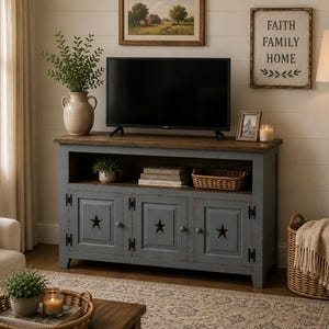 May include: A blue wooden media console with a dark brown top, featuring three cabinet doors each adorned with a cutout star design, black metal hinges, and an open storage shelf containing books and a small woven basket for media storage.