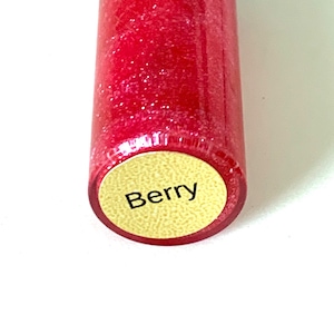 May include: A red lip gloss tube with a gold label that says "Berry".