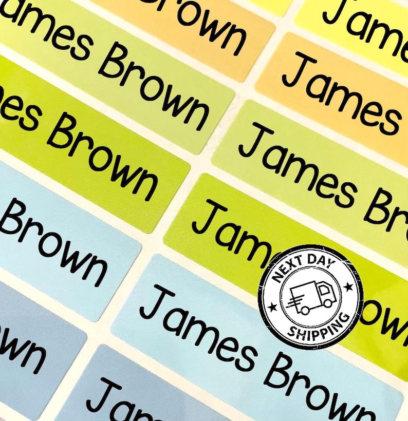 May include: A sheet of rectangular adhesive labels in shades of yellow, lime green, and light blue. Each label features the name James Brown printed in a bold black sans-serif font. A circular black and white stamp with a truck icon is present.