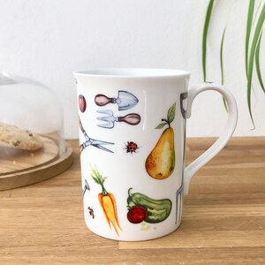 Gardening bone china mug with garden tools, vegetables, flowers and ladybirds on the outside.