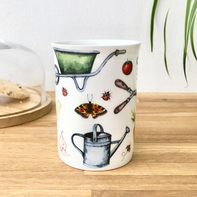 Gardening bone china mug with garden tools, vegetables, flowers and ladybirds on the outside.