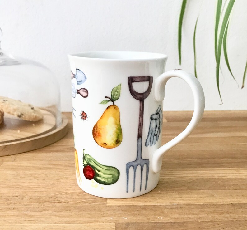 Gardening bone china mug with garden tools, vegetables, flowers and ladybirds on the outside.
