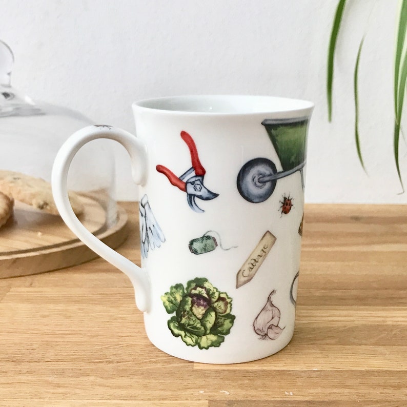 Gardening bone china mug with garden tools, vegetables, flowers and ladybirds on the outside.
