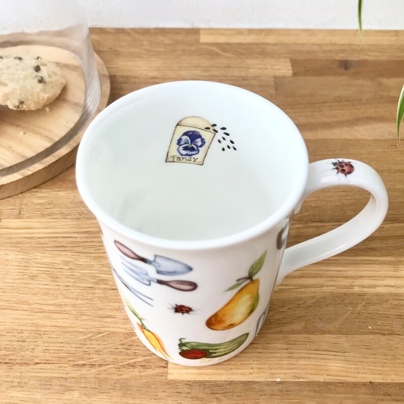Gardening bone china mug with a small packet of pansy seeds on the inside