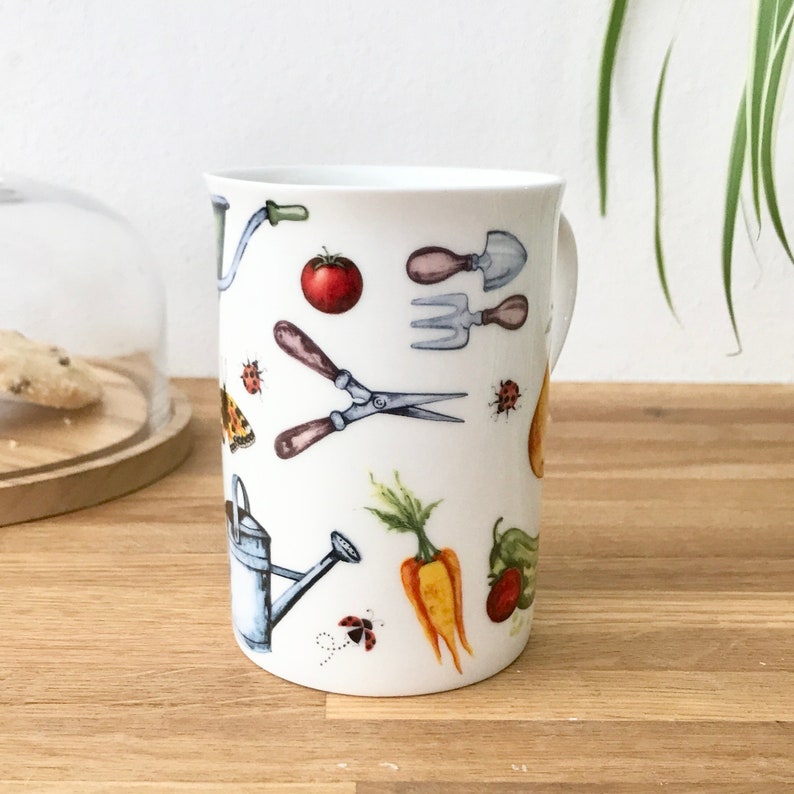 Gardening bone china mug with garden tools, vegetables, flowers and ladybirds on the outside.