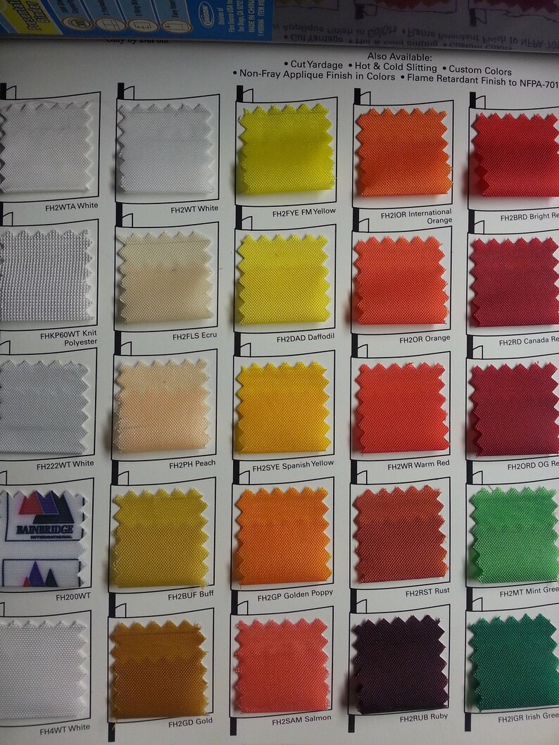 Peut inclure: Un nuancier de tissus pr&eacute;sentant des &eacute;chantillons de diff&eacute;rentes couleurs, notamment blanc, jaune, orange et rouge. Le nuancier comprend des &eacute;tiquettes de texte telles que "FH2WTA White" et "FH2FYE FM Yellow". Le logo Bainbridge International est visible.