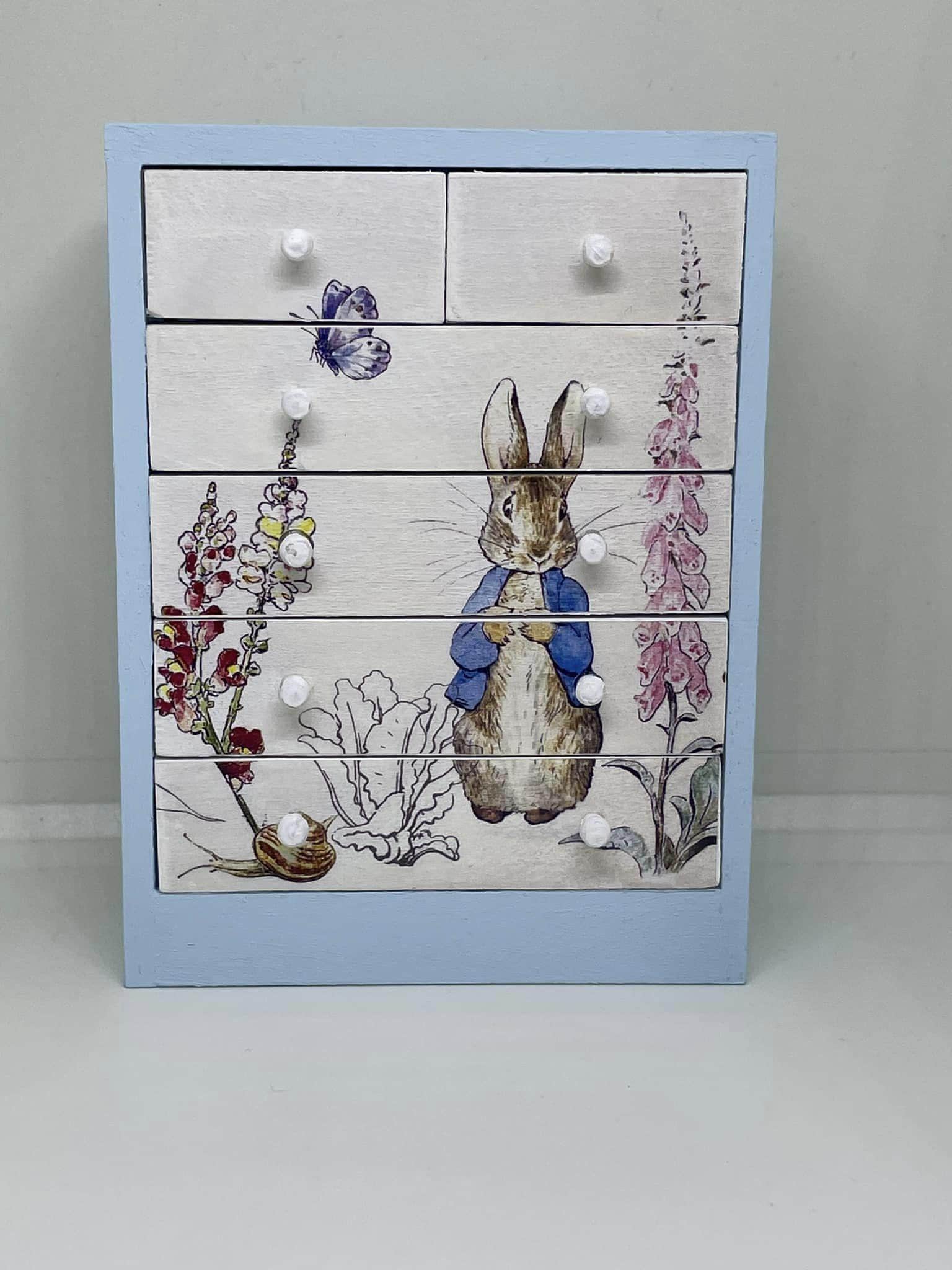 Handmade 1:12th scale miniature dolls house furniture chest of drawers painted blue and finished with Peter Rabbit themed decals