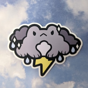 Może przedstawiać: Fioletowa kreskówkowa żaba z ponurym wyrazem twarzy przedstawiona jako chmura z kroplami deszczu i żółtym błyskawicą. Żaba jest naklejką.