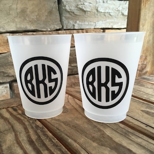 May include: Two white plastic cups with black circles and the letters "BKS" printed on them.