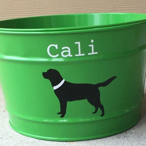 May include: Green metal bucket with a white silhouette of a dog and the name "Cali" written in white letters.