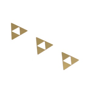 Op de afbeelding: Drie gouden driehoekige metalen bedels met een kleiner vierkant uitgesneden in het midden van elke driehoek.