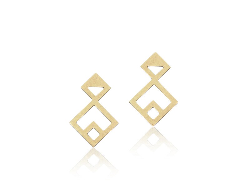 Puede incluir: Un par de pendientes geom&eacute;tricos de oro con forma cuadrada y un dise&ntilde;o de corte.