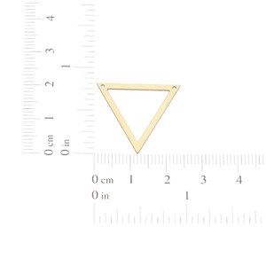 May include: Gold triangle pendant with two holes at the top. The pendant is approximately 2 inches wide.
