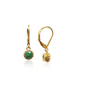 May include: Gold earrings with a green gemstone set in a gold crown-shaped setting. The earrings have a lever back closure.