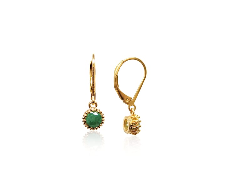 May include: Gold earrings with a green gemstone set in a gold crown-shaped setting. The earrings have a lever back closure.