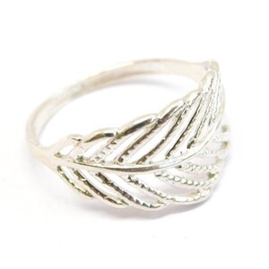 May include: A silver ring with a delicate feather design. The feather is made of thin, intertwined lines, creating a delicate and intricate look.