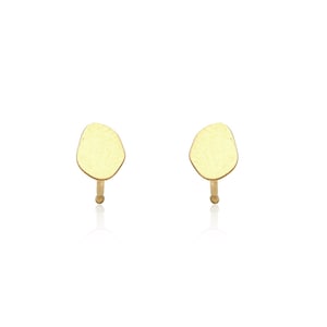 Op de afbeelding: Een paar gouden oorbel studs met een licht onregelmatige, organische vorm.