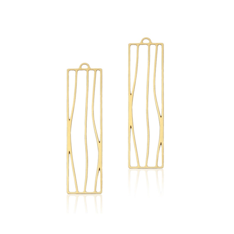 May include: A pair of gold-toned earrings with a geometric design. The earrings are made of thin metal and have a rectangular shape with a curved line pattern.