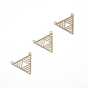 May include: Three gold-toned metal triangle charms with a geometric design. Each charm has three holes for attaching to jewelry.
