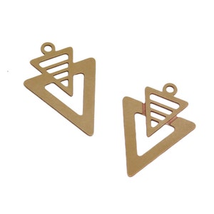May include: Two gold-toned metal triangle charms with a smaller triangle cut out in the center. The charms have a hole at the top for attaching to jewelry.