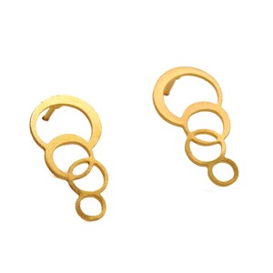 May include: A pair of gold-toned earrings with a cascading circle design. Each earring features four interlocking circles of varying sizes.