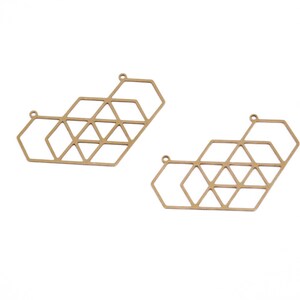 May include: Two gold-toned metal geometric shapes with a hexagonal design. The shapes are open and have a delicate, intricate pattern.