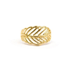 May include: A gold leaf ring with a delicate, intricate design. The ring is made of a smooth, shiny metal and has a simple, elegant style.