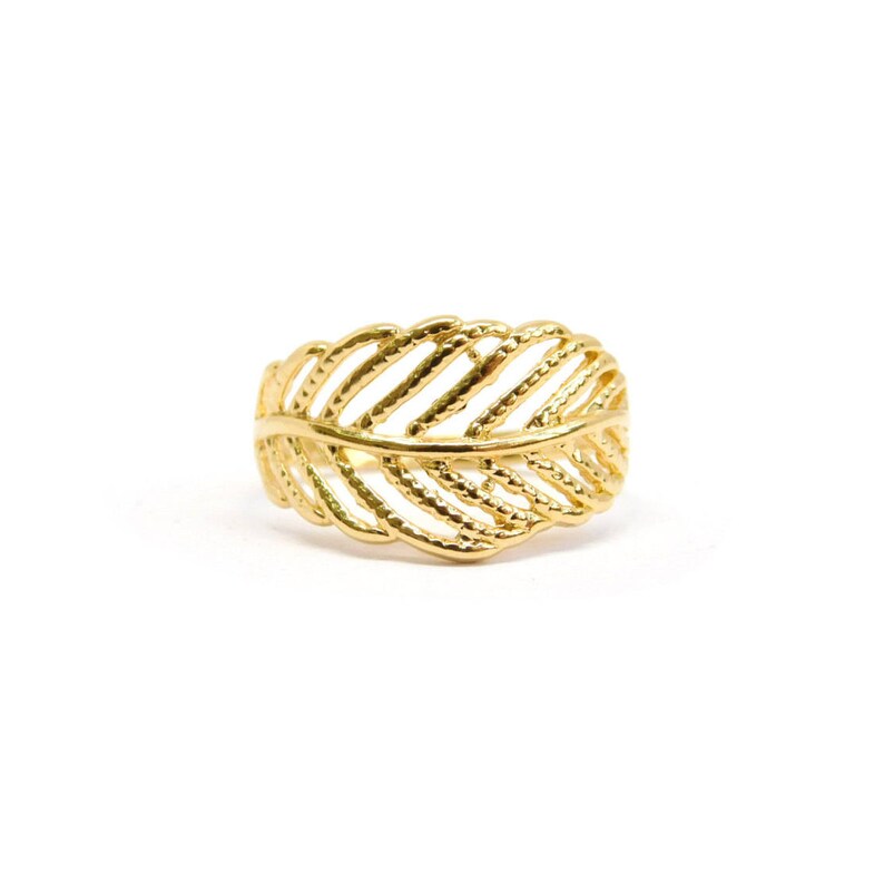 May include: A gold leaf ring with a delicate, intricate design. The ring is made of a smooth, shiny metal and has a simple, elegant style.