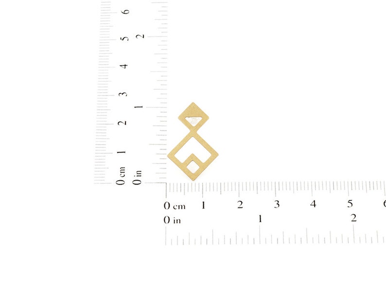 Puede incluir: Un dise&ntilde;o geom&eacute;trico de metal dorado con una forma de diamante en el centro. El dise&ntilde;o mide aproximadamente 2,5 cm de alto y se mide con una regla.