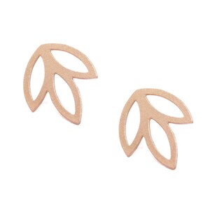 May include: A pair of gold-toned earrings featuring a leaf design. The earrings are made of metal and have a delicate, feminine look.