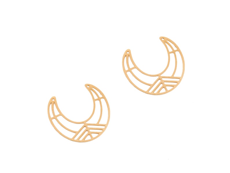 May include: Two gold-colored, crescent-shaped earring components. Each component features a geometric design with a series of straight lines and angles, creating an open, airy appearance. The earrings have small holes at the top for attachment.