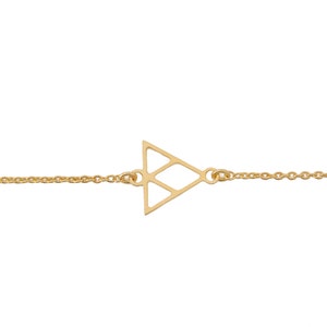 Puede incluir: Un brazalete de cadena dorada con un colgante de triángulo geométrico.