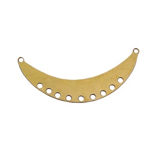 May include: Gold metal crescent moon shaped pendant with multiple holes for attaching jewelry findings.