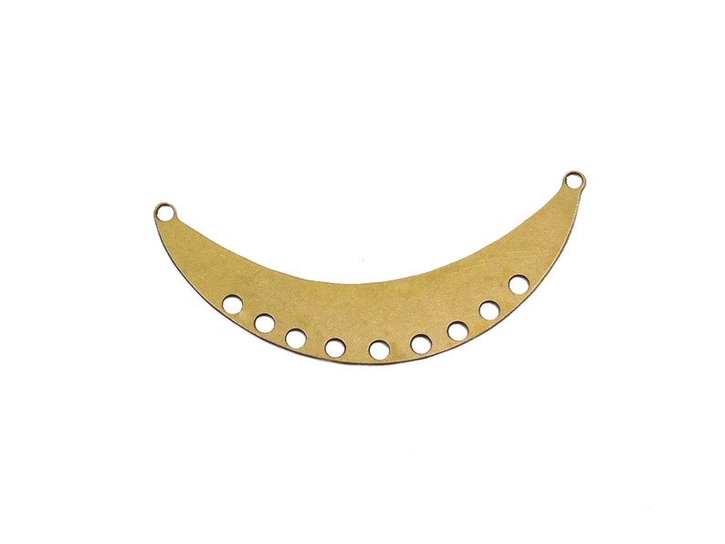 May include: Gold metal crescent moon shaped pendant with multiple holes for attaching jewelry findings.