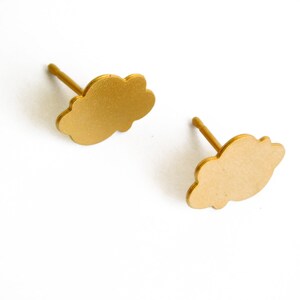 Könnte beinhalten: Ein Paar goldene Ohrstecker in Wolkenform.