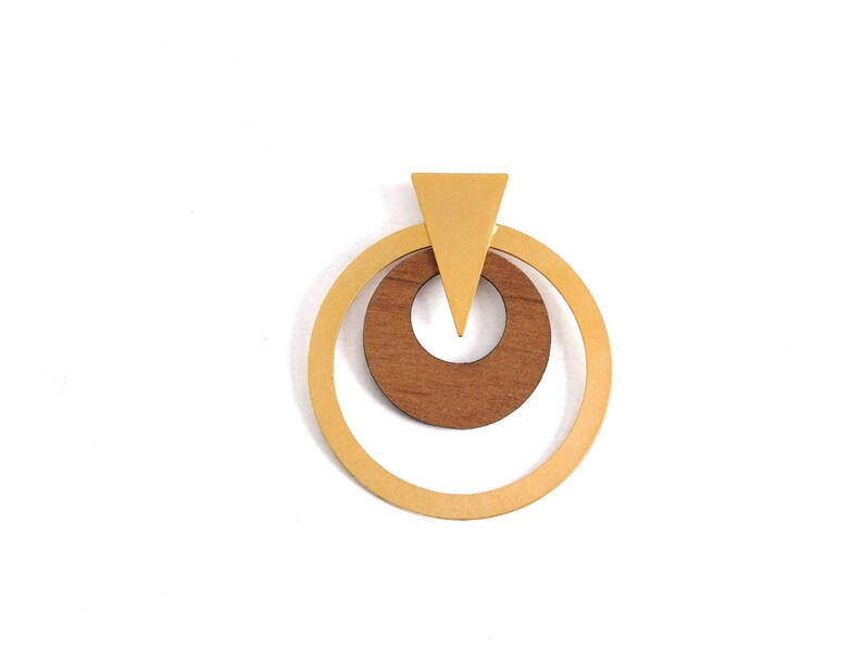 Op de afbeelding: Een geometrische hanger met een lichtbruine houten cirkel in een grotere, lichtgele cirkel. Een lichtgele driehoek bevindt zich boven de cirkels. De hanger is geplaatst tegen een witte achtergrond.