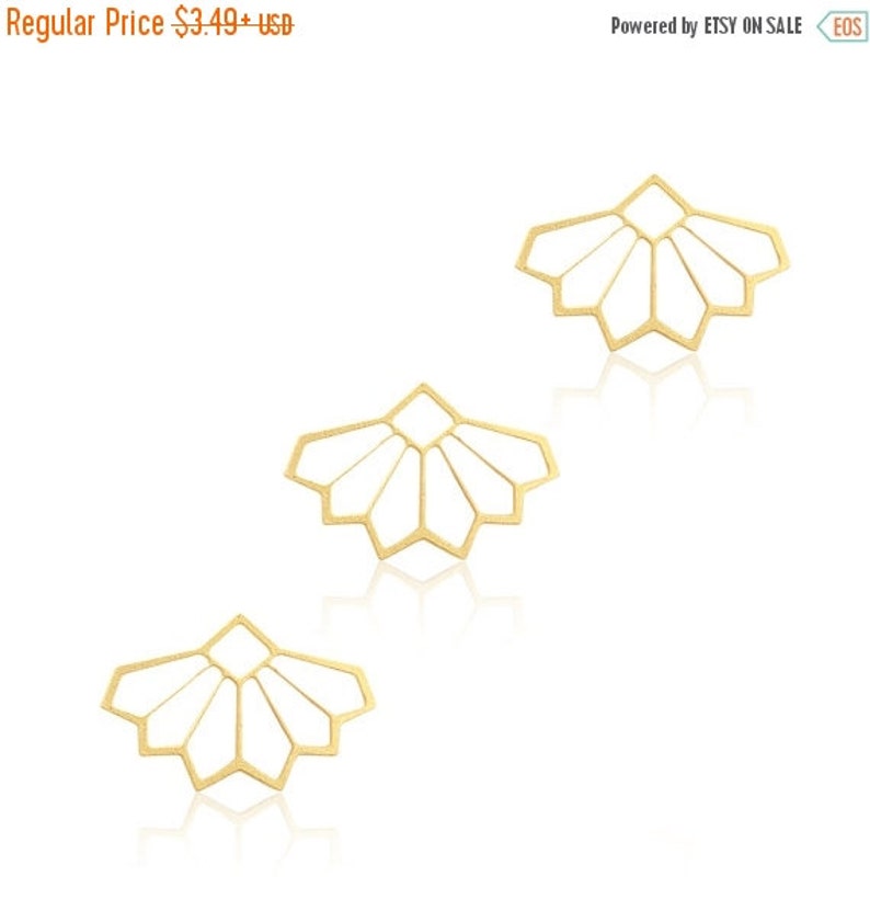 May include: Three gold-colored metal geometric shapes with a starburst design. The shapes are arranged in a triangular pattern.