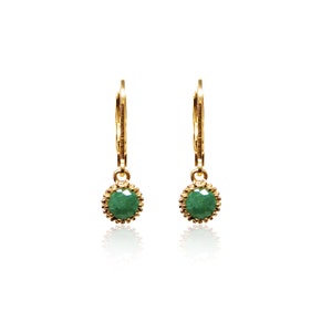 May include: A pair of gold hoop earrings with a green gemstone dangle. The earrings have a delicate, feminine design.
