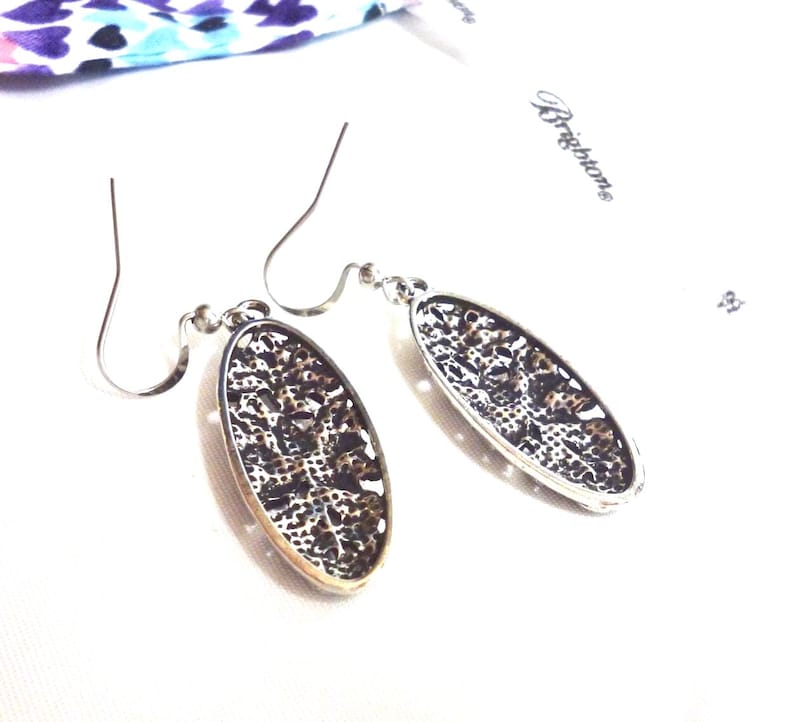 The backs of the earrings show a crosshatch textured design.