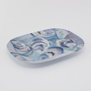 May include: A blue and white oval serving tray with a swirling abstract pattern. The tray is made of ceramic and has a glossy finish.