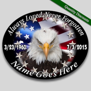 May include: Oval-shaped memorial with a black background, a bald eagle with a serious expression, and an American flag with stars. The text reads "Always Loved-Never Forgotten" with dates "3/23/1960" and "7/3/2015" and "Name Goes Here".
