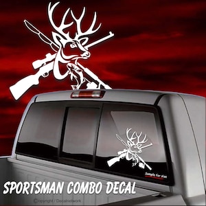 May include: White vinyl decal of a deer with crossed rifles and a fish. The decal is on the back window of a pickup truck. The text "SPORTSMAN COMBO DECAL" is at the bottom of the image.