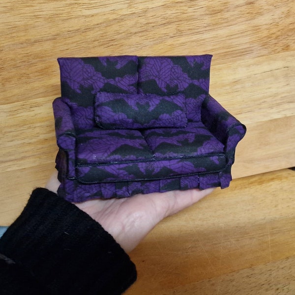 Canapé deux places recouvert de tissu Bat